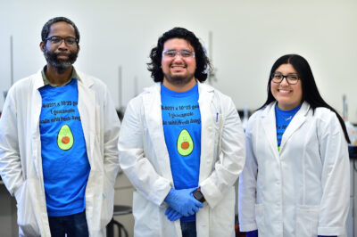 3 Chemistry Research Students wearing lab coats in a lab