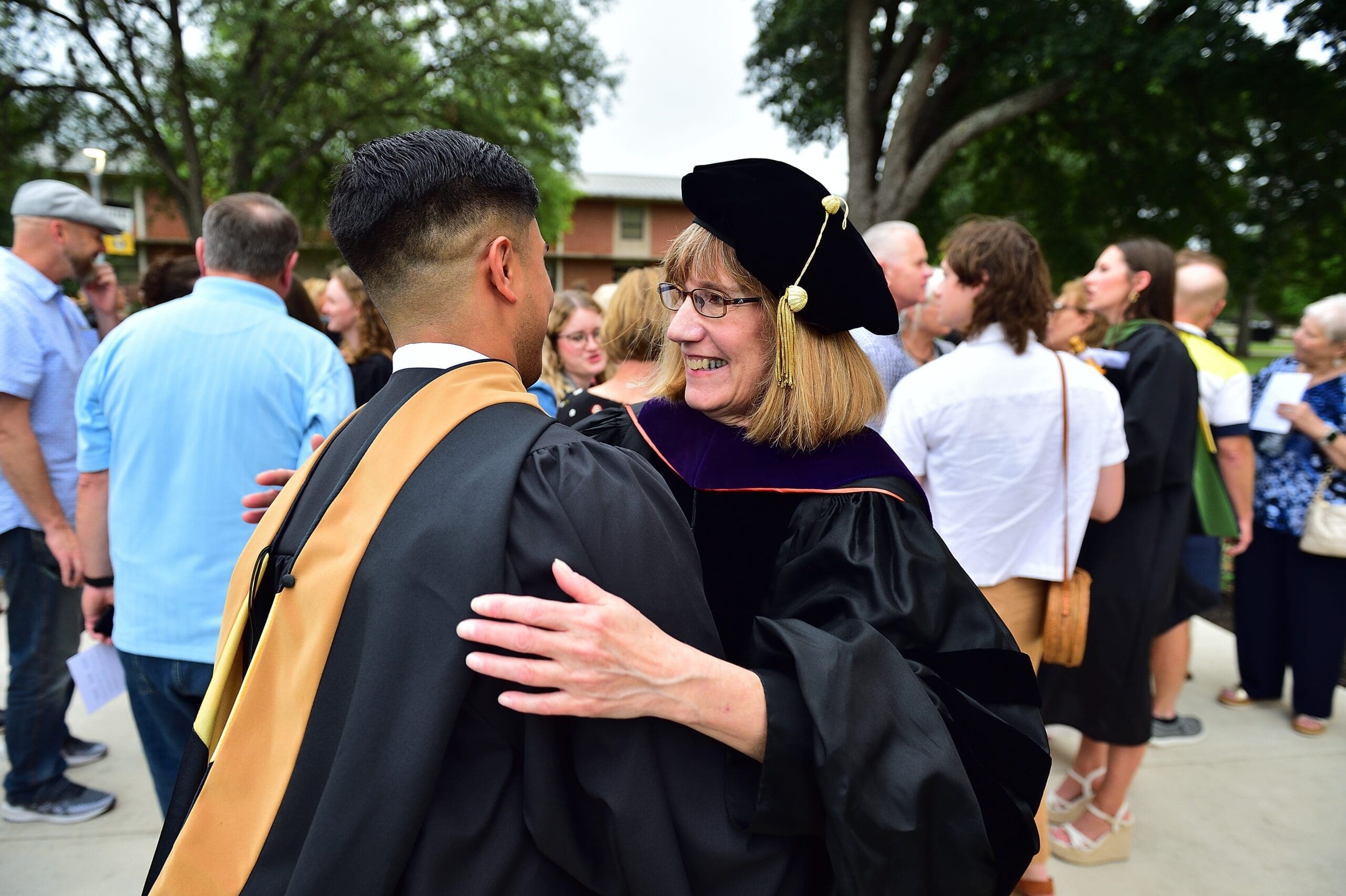 A professor greets a TLU business graduate