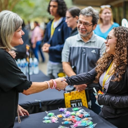 Image of a female TLU employee shaking hands with a female prospective student