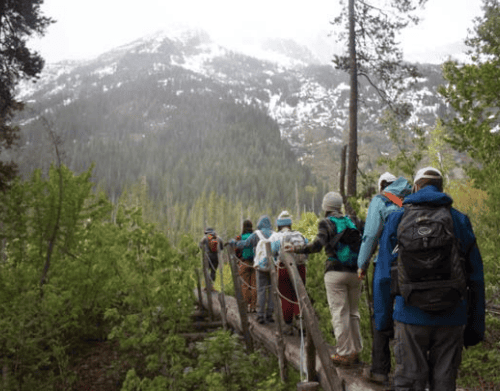 group hiking over bridge