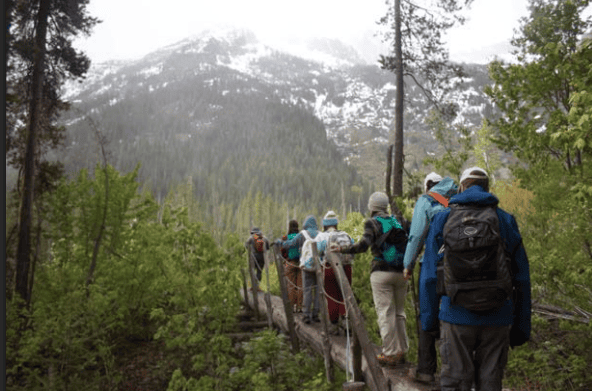 group hiking over bridge