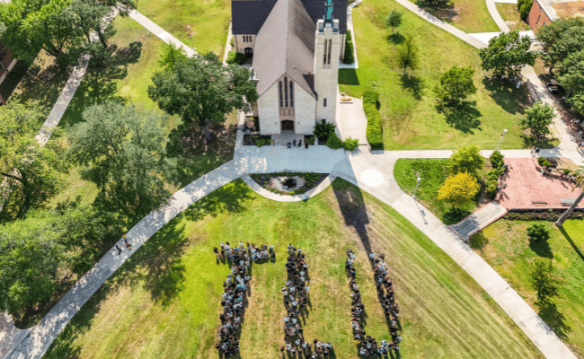 Drone shot of students spelling out TLU in front of chapel