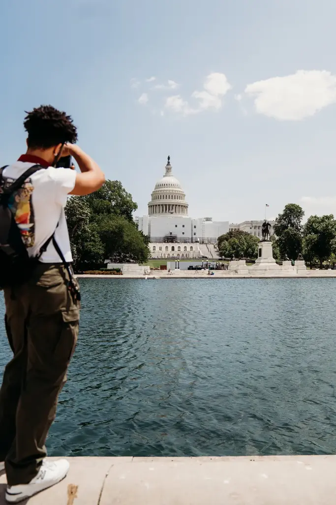 student taking picture over water towards capital
