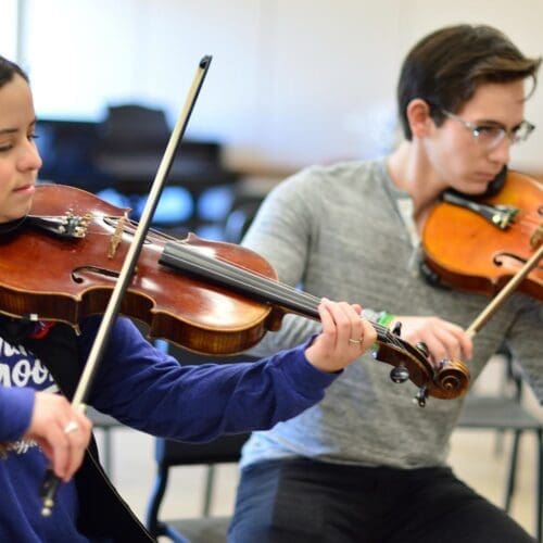 two students playing violins