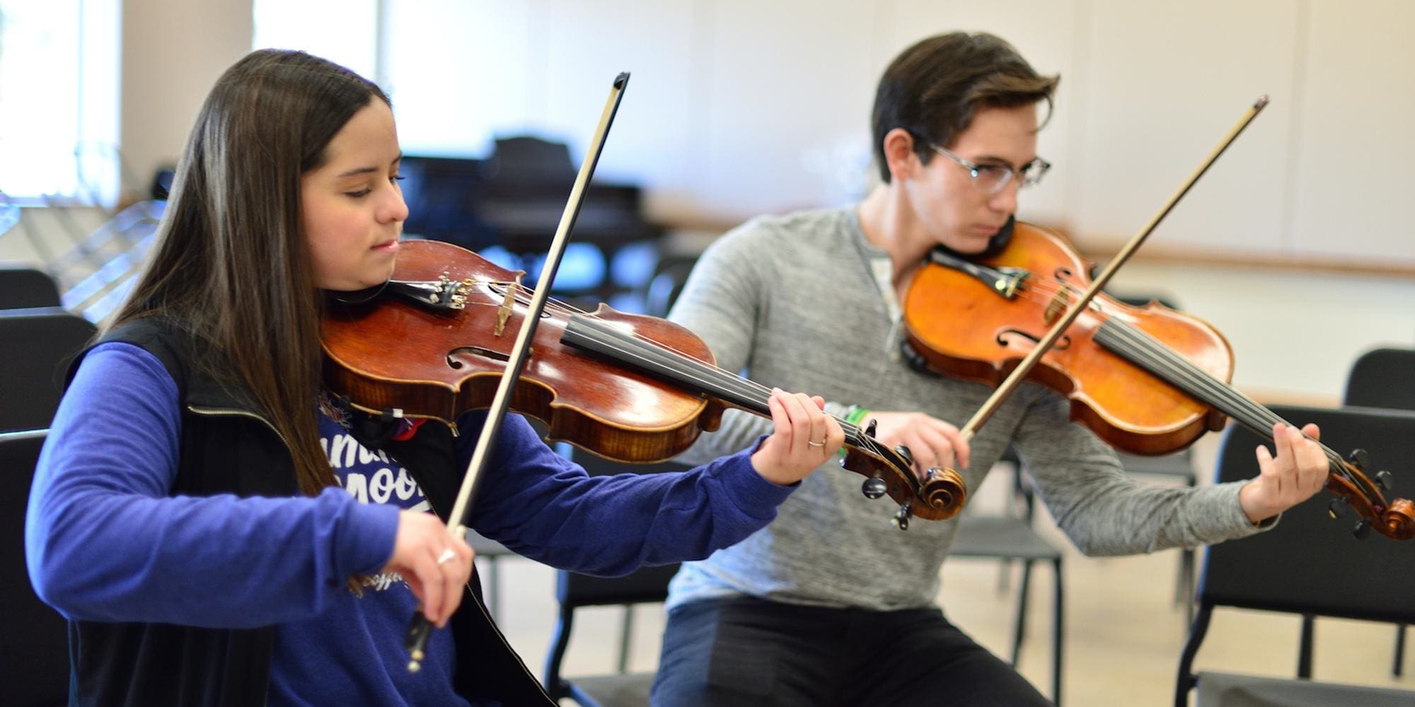 two students playing violins