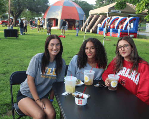 three female students at a student event on campus