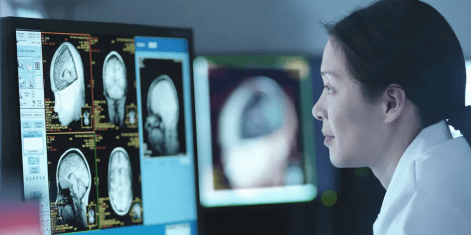 stock photo - student looking at computer with brain scan