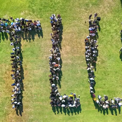 Drone picture of students lined up and forming the letters TLU