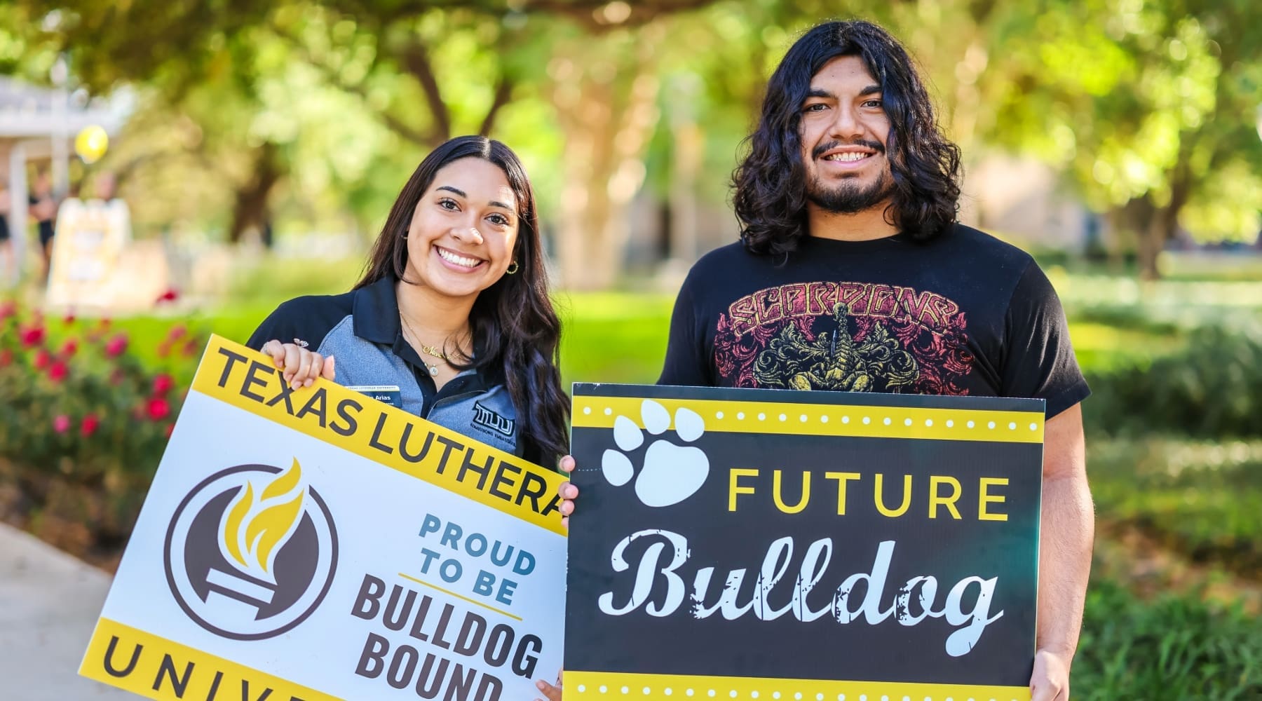Female and Male students holding TLU signs