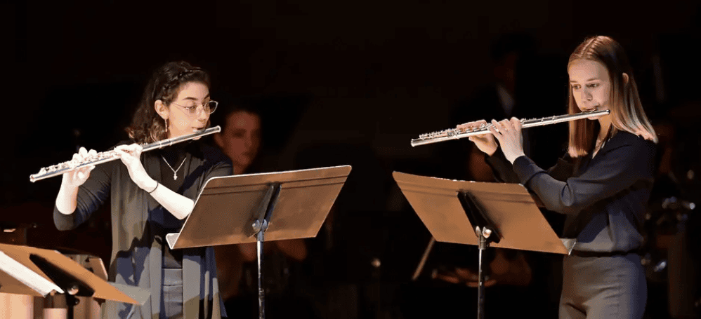 two students playing flutes