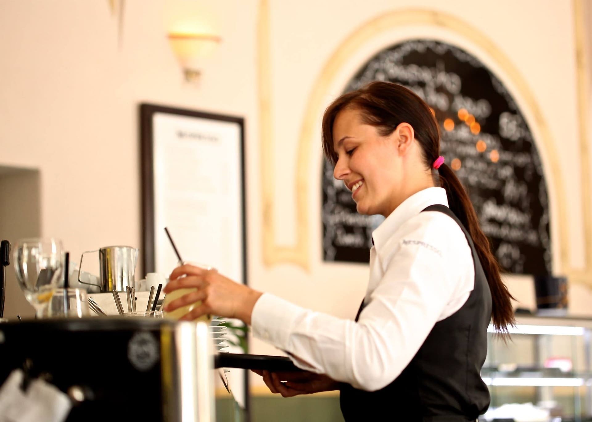 Young waitress preparing a drink.